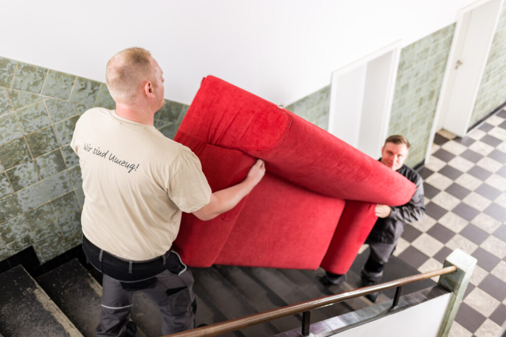 moebeltrager-tragen-ein-schweres-sofa